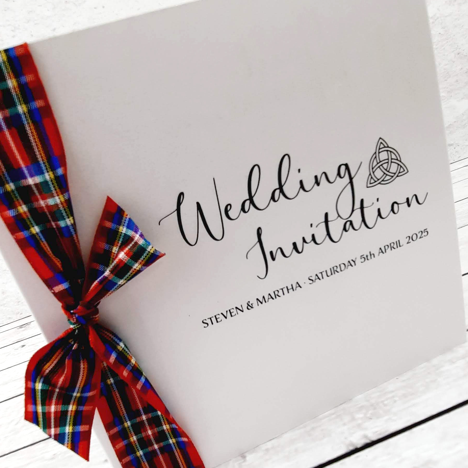 Wedding invitation design with Royal Stewart tartan ribbon and the Trinity Knot.